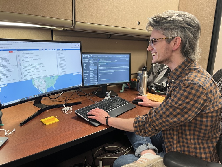 Ronan Hart showing off their Google Earth Engine wizardry in the lab.