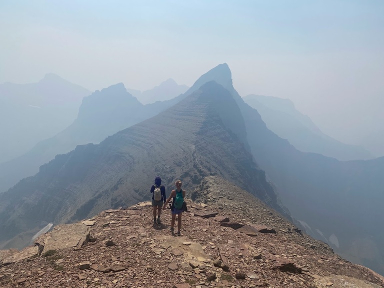 The pika crew descends from the summit of Mt. Cleveland toward Stoney Indian Peaks on a hazy day in Glacier National Park, Montana.