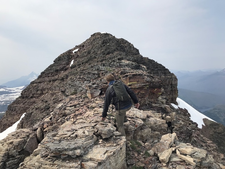 Field technician Michael Cushing nears a summit crag in Glacier National Park, MT.