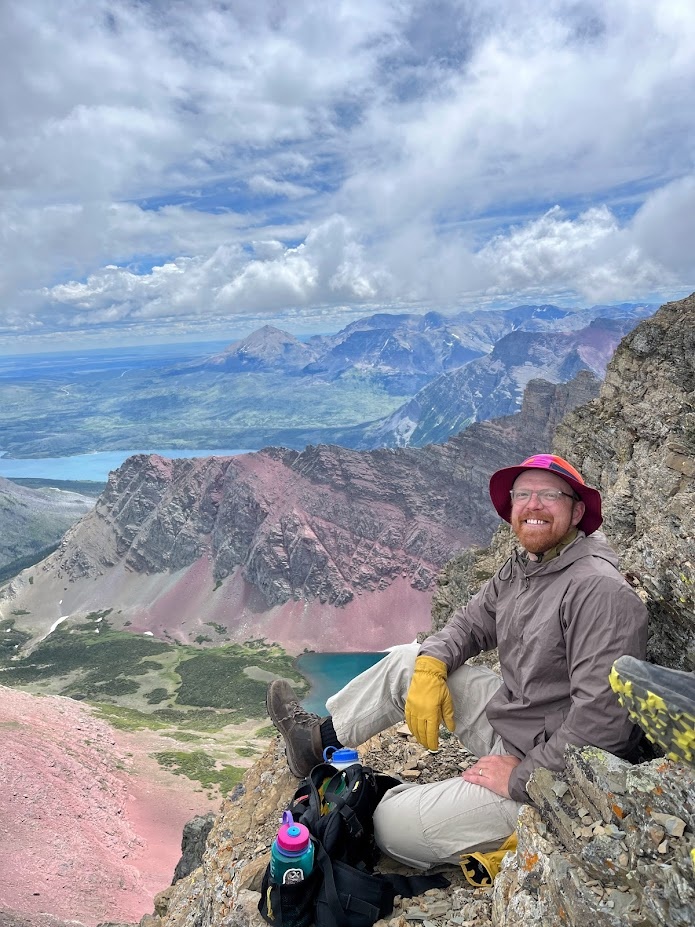 Gavin hiding from the wind on the east side of the summit of Goat Mountain in Glacier National Park, Montana.