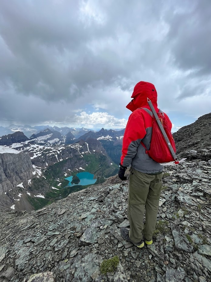 Dr. Lucas Moyer-Horner looking down on Margaret Lake from the summit ridge of Ipasha Peak in Glacier National Park, Montana.